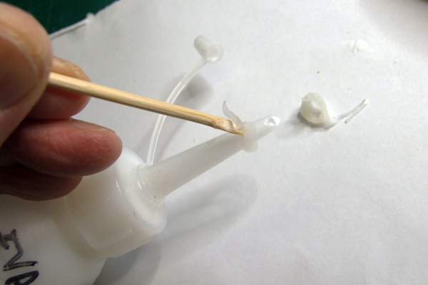 Matchstick made of bamboo cleaning glue off a polythene glue spout