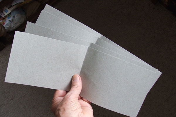 Several sheets of paper being folded into a folio